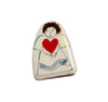 a small pale ceramic brooch with a simple painted angel holding a red heart