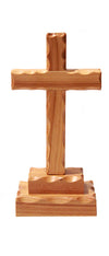 a small wooden cross with scalloped edges fixed to a base of two wooden blocks